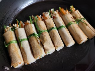 13、豆皮金针菇卷,翻个面再煎一会儿。
