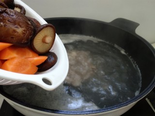 5、排骨胡萝卜鲜虾汤,煮开后，倒入胡萝卜和香菇。