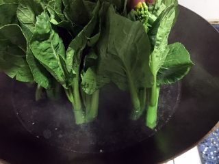 6、白灼菜心,放入青菜，立起来先把菜心的头部先汤30秒，头部比较难熟，如果跟叶子一起汤，叶子容易熟烫太久会变黄烂掉。
