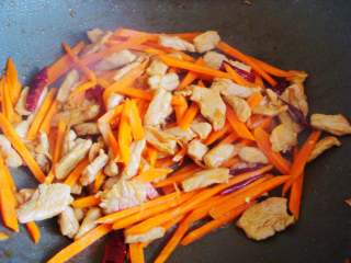 10、青椒炒肉丁,加入生抽继续翻炒上色后倒入胡萝卜。