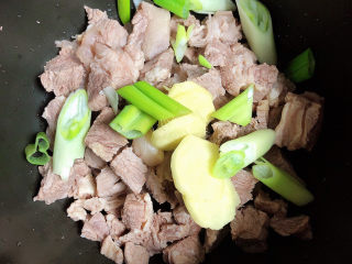 5、萝卜牛腩煲,将牛腩和葱姜都放入高压锅中。