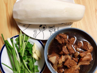 9、萝卜牛腩煲,捞出一碗带汤的牛腩肉。准备好白萝卜、葱蒜、香菜。