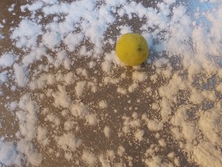 8、南瓜小圆子,面板上撒一层糯米粉,把南瓜糯米团揪一小块,双手揉成圆球,如图