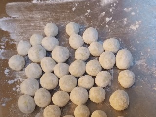 9、南瓜小圆子,依次把剩余的面团都揉成小圆球,在面板上滚一滚,起到防粘作用