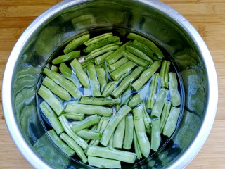 2、干煸四季豆,四季豆用手掰成适当的长段(自认为用手掰比用刀切好吃!),清洗干净泡十分钟。