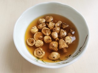 4、花蛤豆腐汤,石渠白菌清洗干净上面的泥沙，然后加饮用水泡着备用。