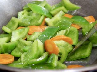 13、青椒炒肉,留原锅油,放入青椒和胡萝卜片翻炒至8分熟,中途可以适当加少许清水