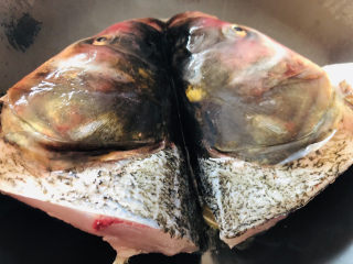3、豆腐鱼头汤,放入处理好的鱼头，最小火煎至1分钟左右。