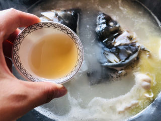 5、豆腐鱼头汤,倒入料酒、姜片去腥。