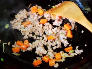 9、茼蒿肉末营养羹,大火继续翻炒至猪肉末断生变色的时候。