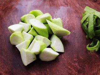 3、丝瓜肉丸粉丝煲,用刀把丝瓜切成菱形块。