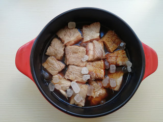 8、【东坡肉】,淋入花雕酒、酱油、加入冰糖，淋入适量水，要没过肉面