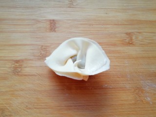 9、大馅馄饨,然后把两头折回来捏紧(怕粘的不紧可以沾点水)，一个馄饨就包好了。