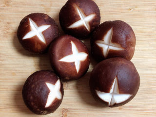 2、海鲜豆腐煲,香菇用刀切成十字花刀。