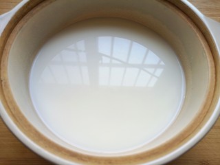 3、奶香南瓜粥,纯净水和牛奶一起放进砂锅烧开。