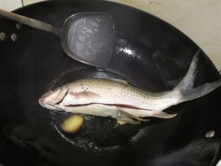 8、粉葛鲮鱼汤,油热（开始冒轻烟）再放入鱼，不要翻动，盖上锅盖，改中小火加热，2～3分钟后再翻面，同样不要翻动，加盖中小火加热2~3分钟后再翻。