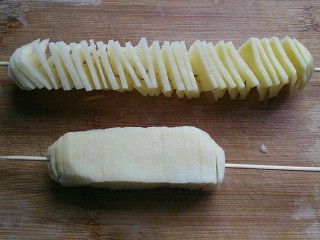 6、孜然土豆塔,切好后，用竹签从中心部分穿过，然后把它稍微拉展开；