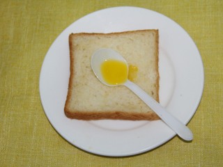 9、幸福早餐烤香蕉土司,在土司上用勺子抹一点黄油