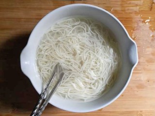 6、紫菜虾皮鸡蛋面,将煮好的面条捞起，倒入开水中。