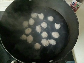 8、自制虾滑,锅中加入适量清水煮开转小火，左手虎口挤出虾丸，右手拿勺子挖挤出来虾丸放入锅中，依次做完，煮至虾丸浮起