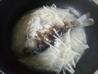 14、鲫鱼萝卜丝汤,加入萝卜丝，鲫鱼大火煮5分钟