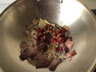 4、腊肉手撕包菜,放入花椒辣椒，豆瓣酱，炒匀