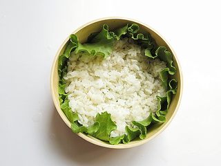 10、兔子趣味便当,消毒过的便当盒用生菜叶铺好,放入少量米饭摊开铺好