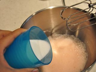 4、最受小朋友喜爱的多彩蛋白糖,细砂糖分三次加入到蛋白中，用电动打蛋器进行打发。