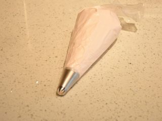 10、最受小朋友喜爱的多彩蛋白糖,将混合好的蛋白糊装入裱花袋中。