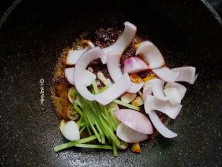 6、回锅肉,放入香芹段、洋葱块、蒜片