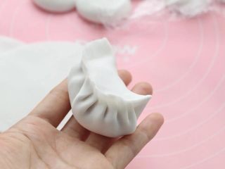 8、水晶蒸饺,不操作的面剂子要盖上保鲜膜防止风干，取一张饼皮在中间放适量馅料，按照个人的习惯手法包成饺子。