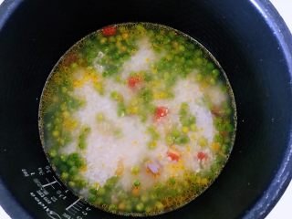 4、豌豆米饭,炒好之后到了电饭锅中，加入米饭，加入豌豆粒，加入水，启动电饭锅煮饭的按钮键，至机子自动工作结束。