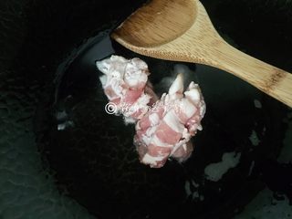 4、泡菜培根炒年糕,起油锅,先把培根放入,煸炒几下。