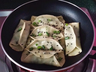 14、磷虾韭菜锅贴,待锅中水干时，开盖撒上葱沫和黑芝麻关火