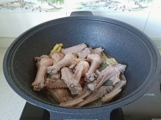 6、红烧鸭翅,热锅凉油下生姜丝炒一下再放入鸭翅翻炒。