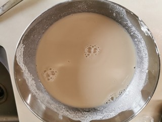 5、爽滑马蹄糕（红豆糕）,把放凉后的糖水倒进之前开好的粉桨，慢慢的边倒进去边顺时针搅拌。直到均匀，用手直接摸一下底，看有没有沉淀。静待10分钟。