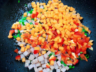 9、青菜炒饭,放入胡萝卜和红椒丁翻炒均匀。