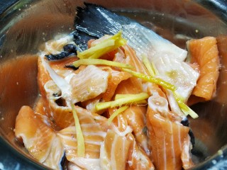 3、香煎三文鱼骨,加入油、盐、姜丝腌15分钟