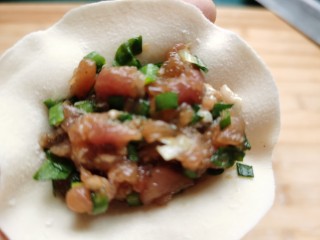 11、韭菜锅贴,将调好的馅料放入面皮上。