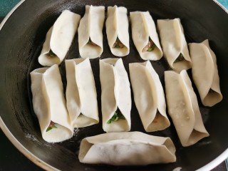 13、韭菜锅贴,平底锅里放少许油，锅不要太热，把锅贴一个个摆放到锅里。