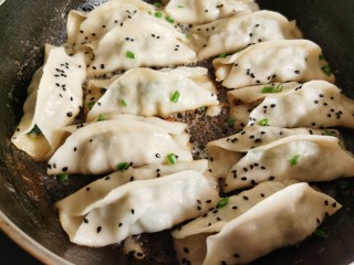 15、韭菜锅贴,等到锅里的水煎干后，打开盖子，撒上少许黑芝麻，再煎一分钟让底部更加干脆，就可以出锅了。