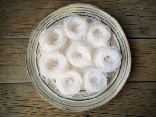 5、蒜蓉蒸大虾,将泡好的粉丝取合适的量绕成粉丝圈摆去盘中。
