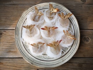 13、蒜蓉蒸大虾,将虾球摆入粉丝圈中间，将虾尾部展开。