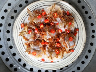 15、蒜蓉蒸大虾,再摆上小米辣圈。上锅隔水蒸，开锅后8分钟即可。时间一到，掀开锅盖，浓郁的蒜蓉香气裹着热浪扑面而来。