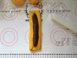 12、南瓜豆沙排包,12、取35克红豆沙馅儿搓长条放在中间。