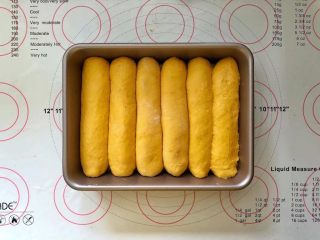 14、南瓜豆沙排包,14、收口向下码入学厨9寸烤盘中，盖上保鲜膜进行二次发酵。