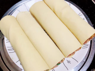 11、千张包肉,将盘子放在蒸锅中，烧开水，中大火蒸15分钟。