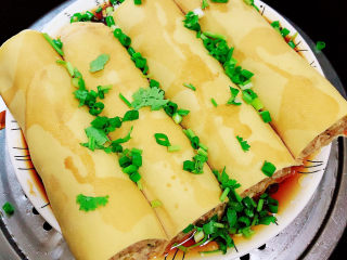 14、千张包肉,撒上一些葱末和香菜末。