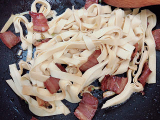 11、韭菜炒千张,加入盐、酱油翻炒均匀。