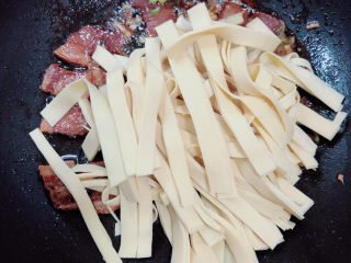 10、韭菜炒千张,放入豆皮翻炒均匀。